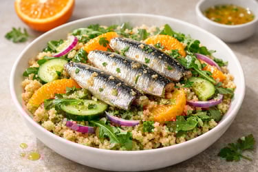 Warm bowl of quinoa citrus salad topped with sardines 