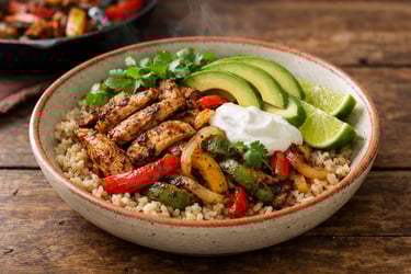 Tazón de fajita de pollo con tiras de pimiento y cebolla carbonizados sobre arroz integral, aguacate en rodajas, cilantro fresco, gajo de lima al lado