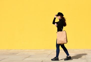 A young woman carrying a bag of healthy food
